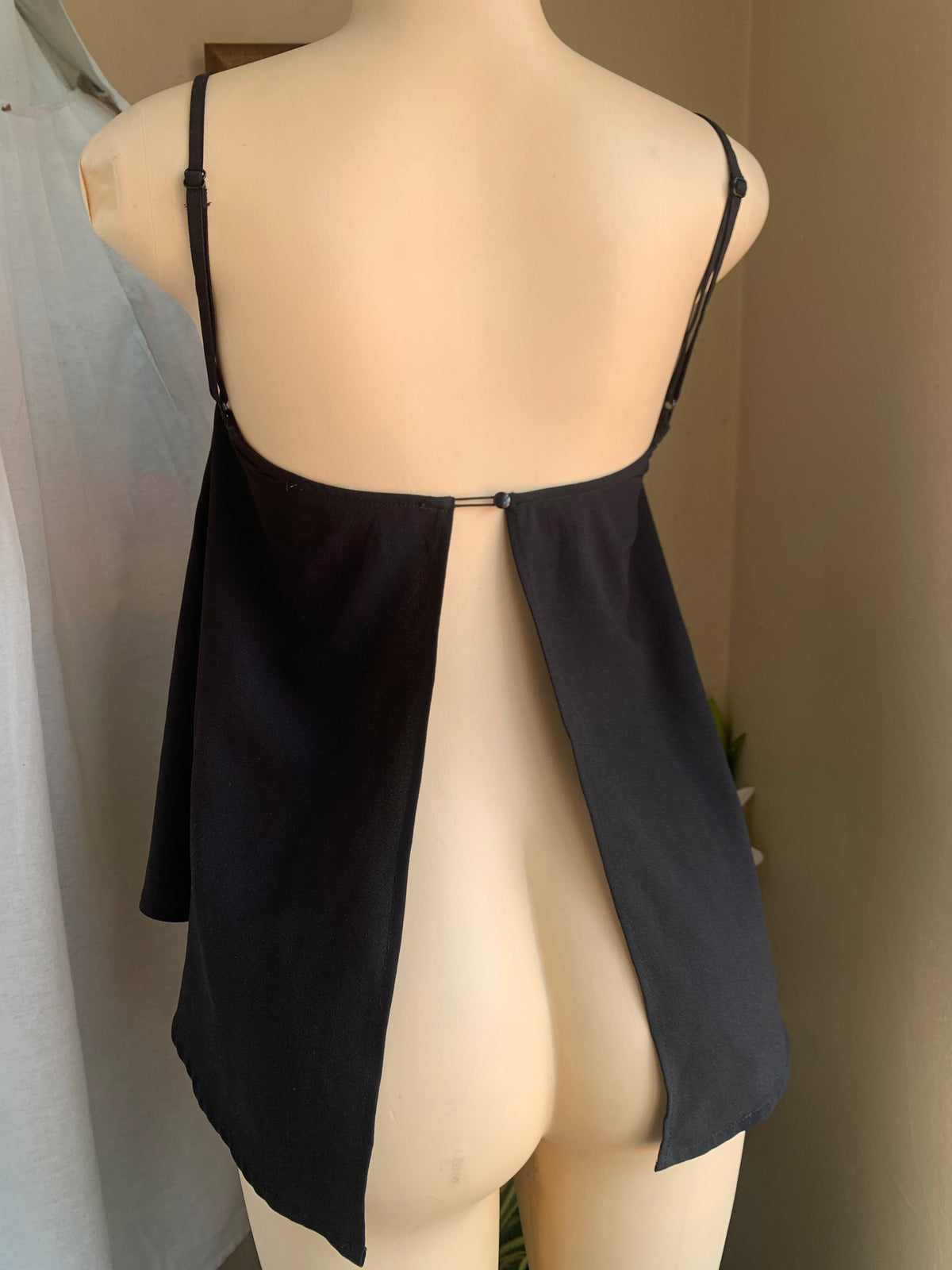 Black spaghetti tank with open back … says s